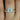 Close-up of 14kt rose gold round moissanite and diamond bridal set on hand
