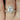 Mae 9x7mm Cher & Tabitha 14kt Rose Gold Oval Moissanite and Diamond Halo TRIO Bridal Set featuring a stunning 9x7mm oval moissanite center stone surrounded by a halo of sparkling diamonds