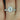 Close-up view of Rebecca 8x6mm & Petite Naomi 14kt White Gold Oval Moissanite and Diamond Halo Bridal Set with sparkling diamonds and elegant design