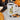 Steaming coffee mug with golden citrine crystal design beside Halloween pumpkins and candy on a cozy cloth.