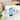 White ceramic mug featuring artistic blue aquamarine crystals and inspirational text on a kitchen counter.