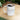 White ceramic mug with aquamarine-themed March birthstone design filled with coffee on wooden table