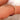Gold ring with small diamonds on a finger against a blurred background