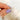Gold ring being held by a hand with purple nail polish on a soft white background