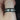 Liam 7mm Black Zirconium Beveled Edge & Double Grooved Pipe Band ring displayed on a dark velvet cushion with elegant presentation