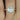Ready to Ship Barra 9mm 14kt Rose Gold Round White Topaz and Diamonds Cushion Halo Engagement Ring on display with sparkling gemstones