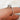 Close-up of a handcrafted 14kt gold moissanite halo ring by rosados box on a finger with a neutral background
