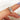 trilogy ring on a finger with a blurred background