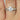 Elegant Tilly 8x6mm 14kt White Gold Forever One Moissanite Diamond Pave Oval Twisted Engagement Ring with a dazzling oval moissanite stone and intricate pave diamond detailing