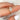 Gold ring with a diamond on a finger against a blurred background