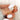 Gold cluster ring with a diamond on a hand with white nail polish against a blurred background