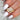 oval cluster ring on women's finger with feather background