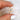 antique cut cushion button back solitaire with diamond accents held between thumb and pointer finger