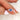 cornflower blue sapphire three stone ring  between finger and white background