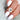 antique cut cushion button back solitaire with diamond accents on middle finger with white nail polish and white background