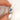 cornflower blue sapphire three stone ring between two fingers on white background