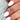 oval cluster ring with cornflower sapphire center stone on middle finger over sleeve