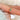 oval green sapphire ring in three stone style with two diamonds on 14kt gold on pointed finger