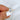 six prong oval diamond solitaire ring in yellow gold on finger pinched by finger