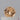 A close-up image of a 039 carat round apricot champagne sapphire gemstone